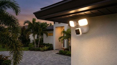 Alarm.com outdoor floodlight security camera mounted on Florida home at dusk