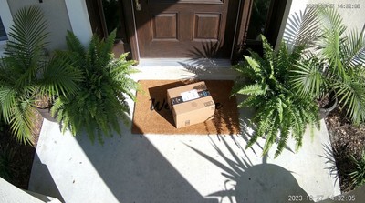 Doorbell camera view of package delivered to front porch