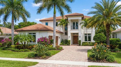 Beautiful modern Florida home with tropical landscaping and palm trees