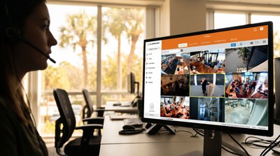 Security operator reviewing live video verification feeds in a bright Florida office